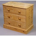 A pine dwarf chest fitted three long drawers with turned knob handles, & on a plinth base, 30”