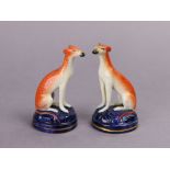 A pair of 19th century Staffordshire pottery small ornaments, each in the form of a seated