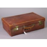An early 20th century tan leather suitcase fitted brass twin-lever locks, 22” wide, & an early