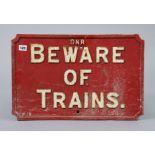 A vintage red & white painted cast iron G.N.R. “Beware of Trains” notice,13¾” x 21”.