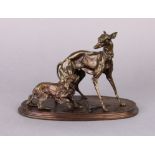 A bronzed sculpture depicting two standing dogs, on an oval base signed “P. J. Mene”, 6¼” high.