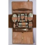 A George V ten-piece travelling toilet set (eight items with silver mounts) London 1917, the leather