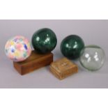 Two green tinted glass fishing floats; together with two other glass fishing floats; & two treen