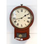 A late 19th/early 20th century drop-dial wall clock with black Roman numerals to the white enamel