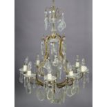 A 19th century style gilt-metal eight-branch chandelier hung with glass prism drops, 23” wide x