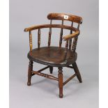 An oak spindle-back child’s chair with a hard seat, & on turned legs with turned stretchers.