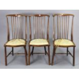 A set of three Edwardian beech lath-back salon chairs each with a padded seat, & on round tapered