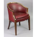 An Edwardian beech-frame tub-shaped armchair upholstered close-nailed leatherette, on square tapered