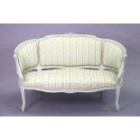 A French Louis XV-style sofa with carved decoration to the painted frame, upholstered striped