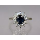 An 18ct. white gold ring set oval sapphire of approx. 1.1. carat, within a border of small diamonds;