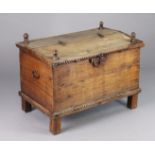 A 20th century Eastern hardwood trunk with a hinged half lid, carved decoration & iron handles, on