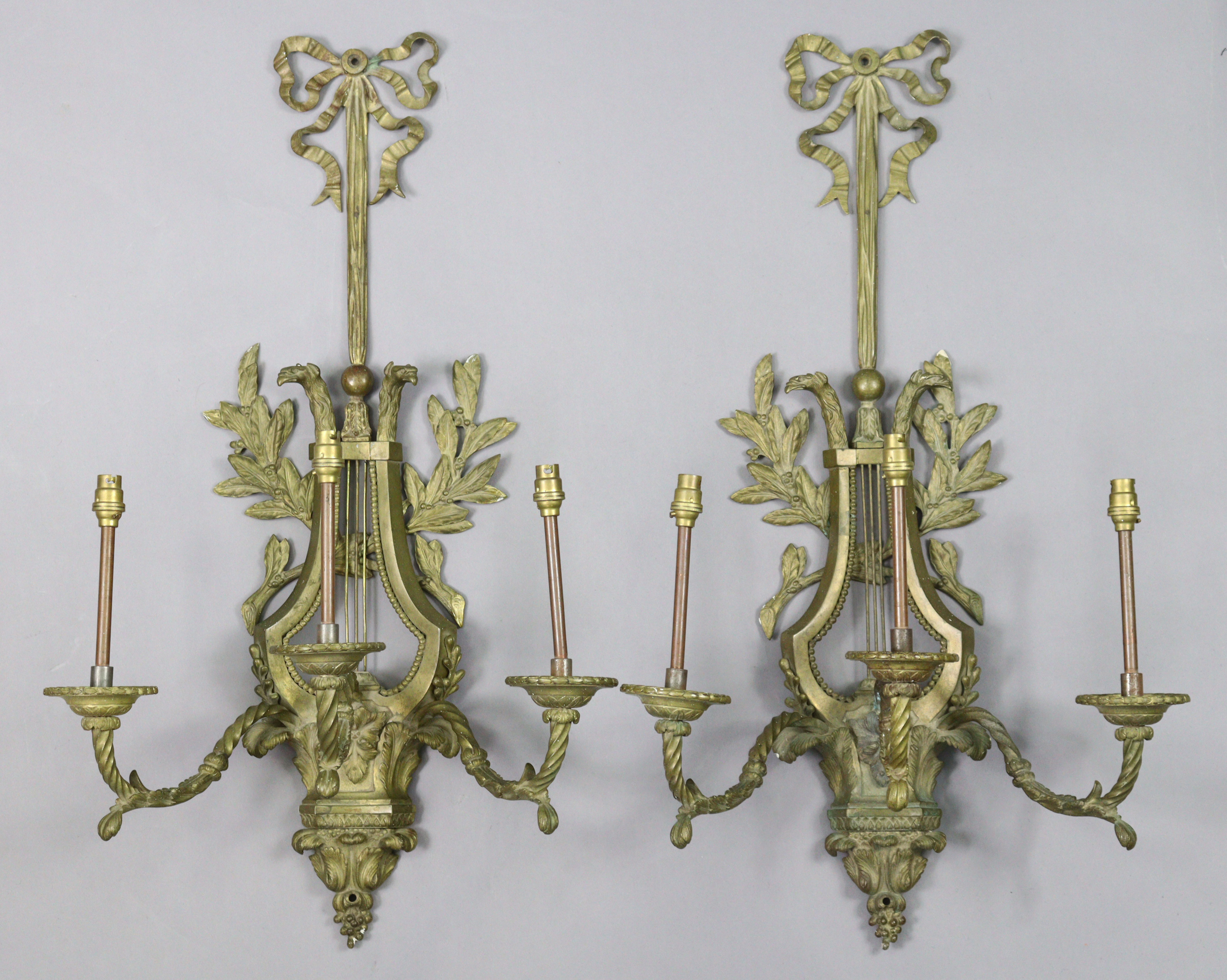 A pair of 19th century gilt-metal lyre-shaped wall sconces, each with three spiral-twist arms,