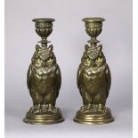 A pair of late Victorian gilt-metal owl candlesticks, each with inset glass eyes, fluted sconce, &on