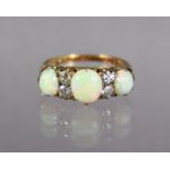 An opal & diamond ring set three oval graduated opals, with pairs of small diamonds in between to