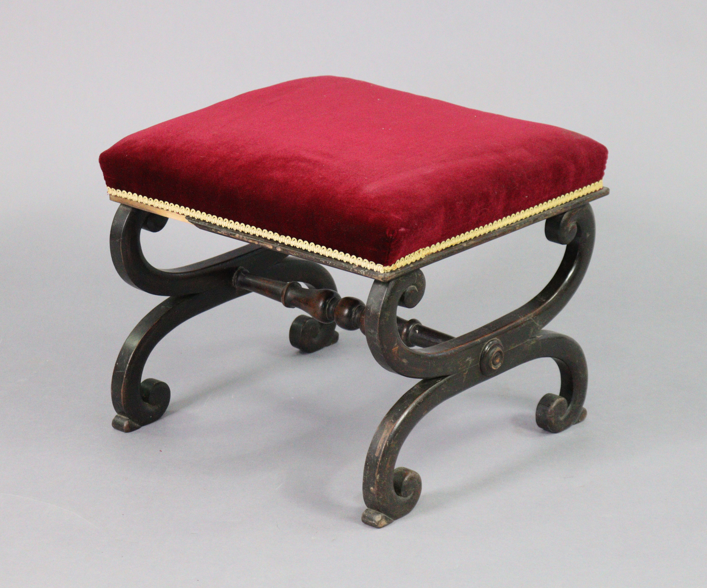 A Victorian mahogany footstool, the padded seat upholstered crimson velour, on curved x-shaped