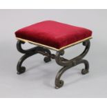 A Victorian mahogany footstool, the padded seat upholstered crimson velour, on curved x-shaped