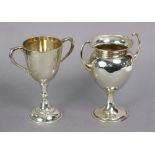 A George V silver trophy cup of ovoid shape with pair of stylised handles & round pedestal foot,