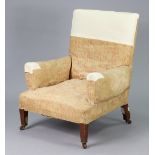 An Edwardian armchair with square back, upholstered fawn coloured fabric with repeating floral