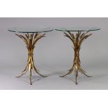 A pair of gilt metal wheatsheaf design side tables, each with circular glass top & on three splay
