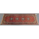 A Kashan rug of madder ground, the central field with repeating floral designs, within multiple