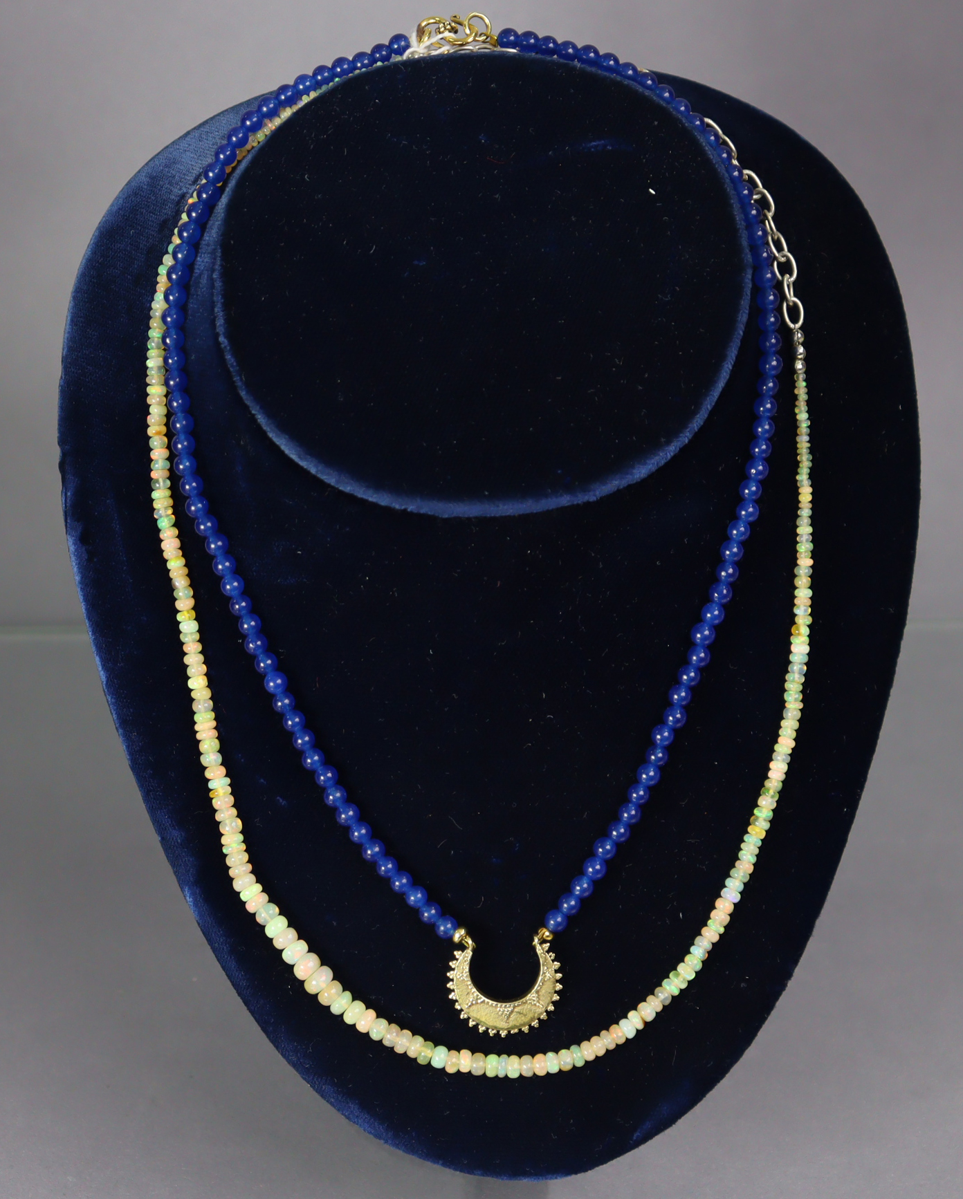 A necklace of graduated opal beads, 50 cm long; & a necklace of near-uniform sapphire beads, with