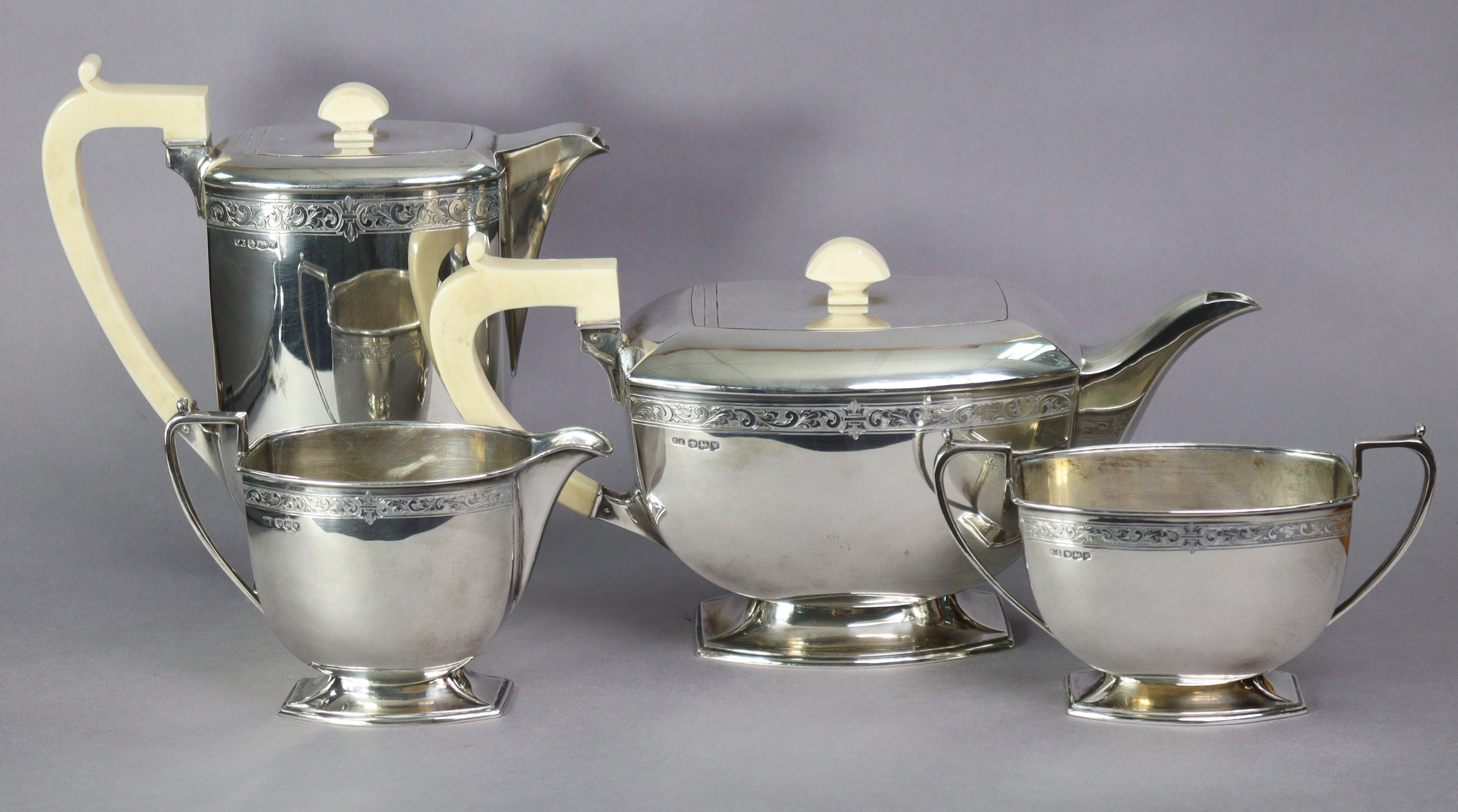 An Art Deco silver four-piece tea & coffee service of curved oblong form, each with narrow band of