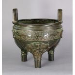 A CHINESE BRONZE TRIPOD CENSER, with archaistic decoration of mask above each round foot, a hand