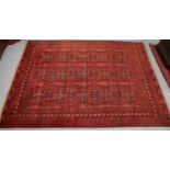 A Bokhara carpet of madder ground with repeating floral designs surrounded by numerous narrow
