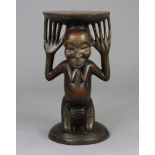 A Luba stool, the female figural support kneeling on circular base, her raised hands supporting