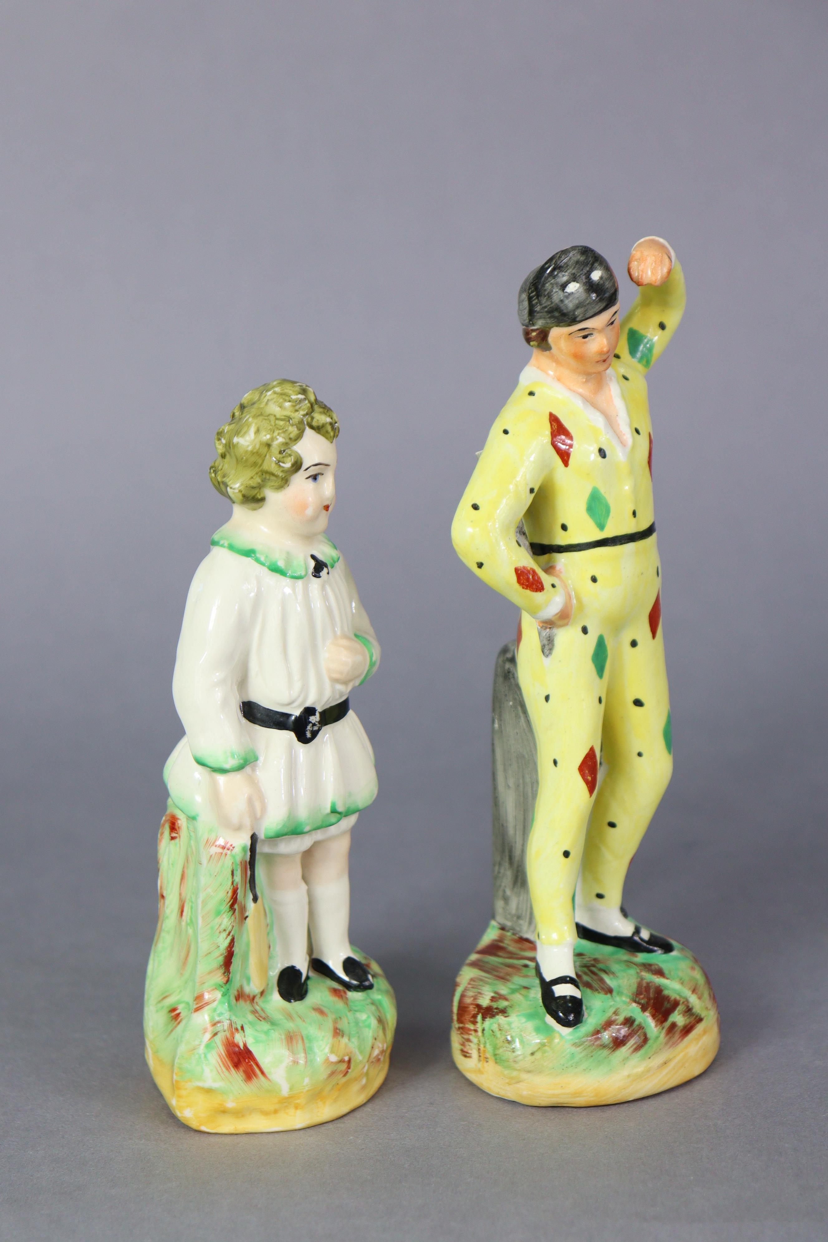 A 19th century Staffordshire pottery figure of a harlequin, & another of a cricketer, each stood - Image 2 of 4