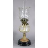 A Victorian brass oil lamp with cut-glass shade & faceted reservoir, on black-glazed ceramic