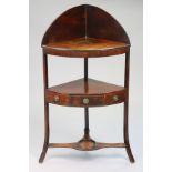 A Regency mahogany bow-front corner washstand with a carved stage back, fitted single drawer to