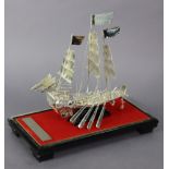 A Chinese white metal model of a sailing junk, with eight oars & armed with three canon, 8" high x 7