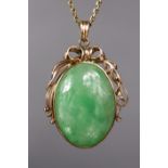 A green jade oval pendant in 14K ribbon-bow & scroll mount, on 14K fine-link necklace.