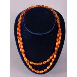A string of seventy-five amber beads of elongated shape & varying caramel tones, 52cm long; each bad