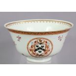 An 18th century Chinese export porcelain bowl with painted armorials in reserves, & floral sprays