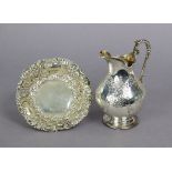 A Victorian silver cream jug with scroll handle & embossed decoration, on round pedestal foot,