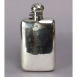 An Edwardian silver pocket spirit flask with bun-shaped hinged screw cap, 5¾” high; Chester 1910, by