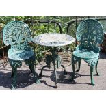 A green painted cast iron patio table with a pierced circular top, & on three shaped legs, 23¼”