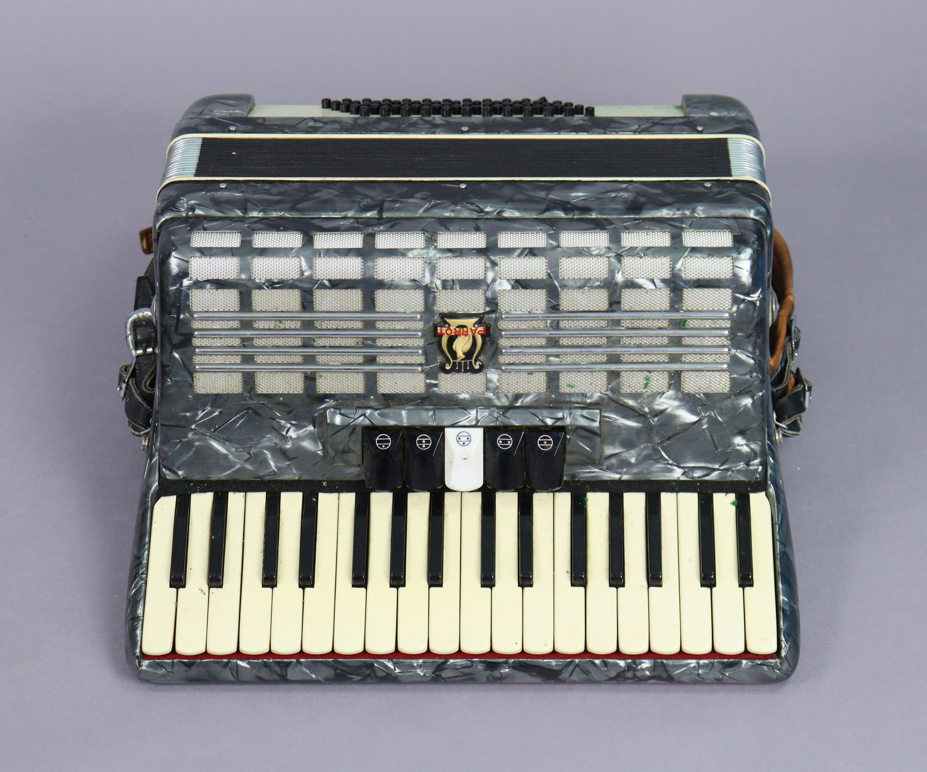 A Parrot piano accordion with a fibre-covered travelling case.