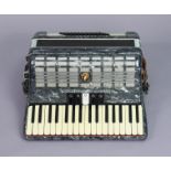 A Parrot piano accordion with a fibre-covered travelling case.