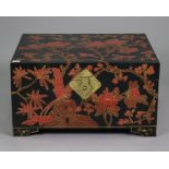 A Chinese black lacquered storage trunk having all-over red, gold, & brown foliate decoration,