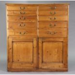 A VICTORIAN PINE TALL CABINET fitted two ranks of five long graduated drawers having brass swing