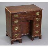 A 19th century mahogany small knee-hole desk fitted with an arrangement of seven drawers, having a