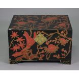 A Chinese black lacquered storage trunk having all-over red, gold, & brown foliate decoration,