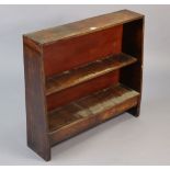 An oak dwarf three tier standing open bookcase fitted two drawers to the lower tier, bears plaque “