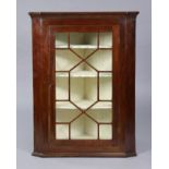 A 19th century mahogany hanging corner cabinet fitted three shelves, enclosed by an astragal