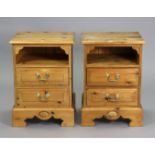 A pair of pine bedside cabinets each with an open recess above two long drawers, & on a shaped