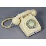 A vintage cream plastic telephone.