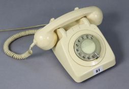 A vintage cream plastic telephone.